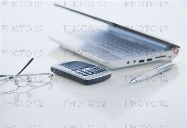 Cell phone and laptop on desk.