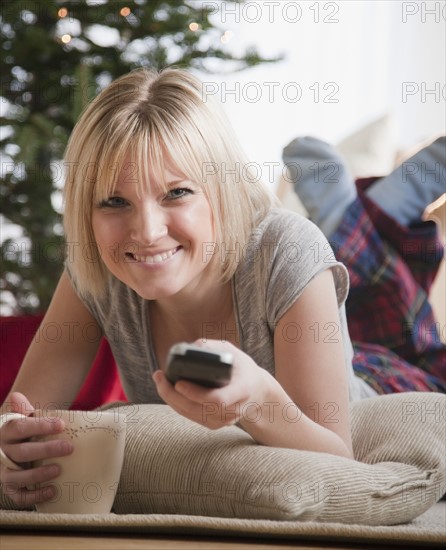 Woman watching television at Christmas. Photographe : Jamie Grill