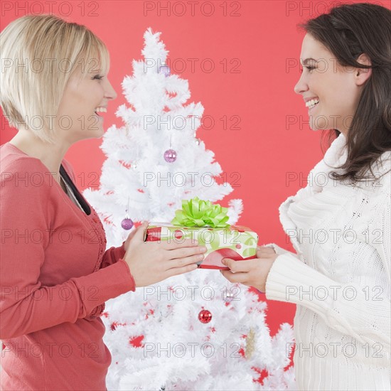 Women exchanging gifts at Christmas. Photographe : Jamie Grill