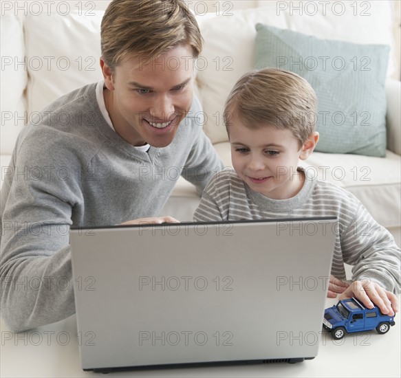 Father and son looking at laptop.