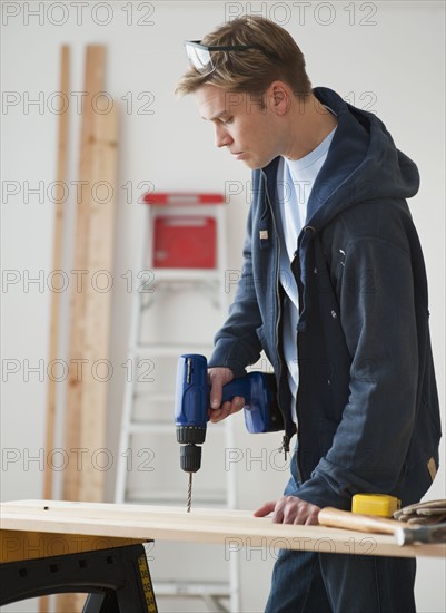 Man drilling on board.