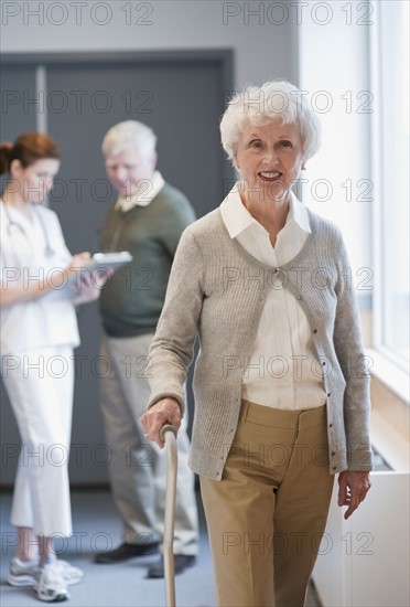 Senior woman walking with cane.