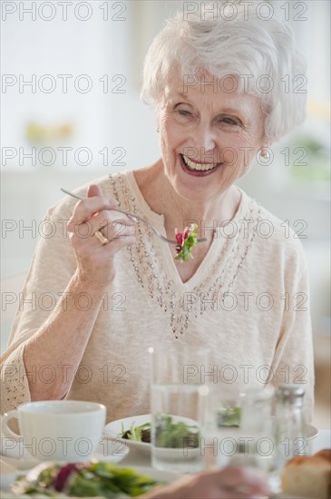 Senior woman eating salad.