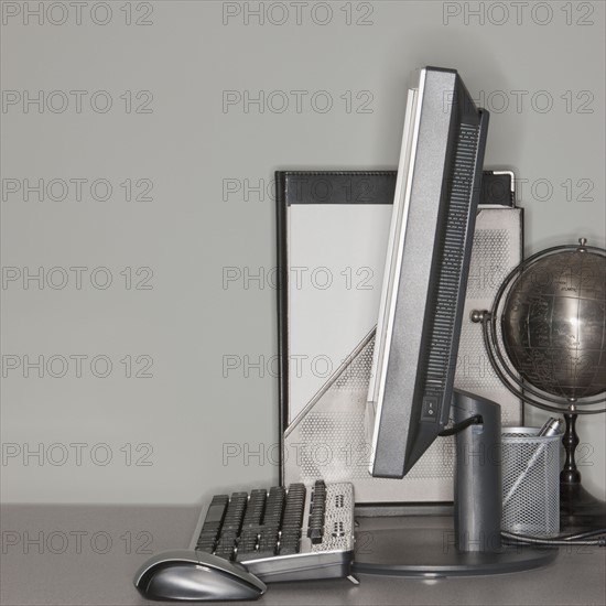 Computer and globe on office desk.