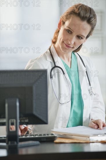 Female doctor looking at computer monitor.