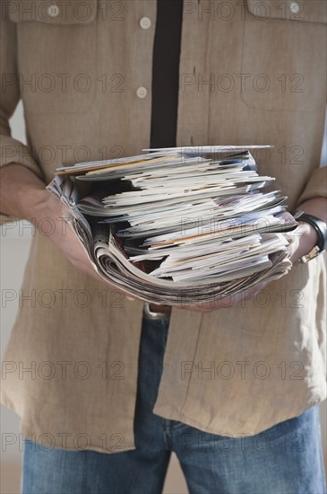 Man holding stack of mail.