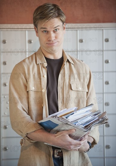 Man holding stack of mail.