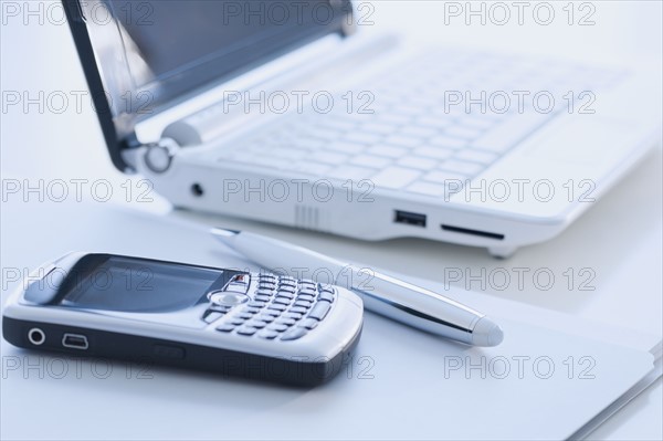 Cell phone and laptop on desk.