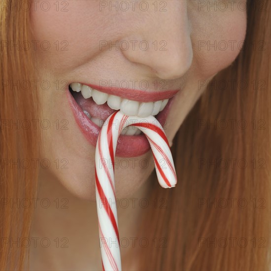 Woman biting candy cane.