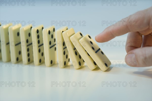 Man pushing row of dominoes.