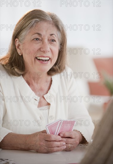 Senior woman playing cards.