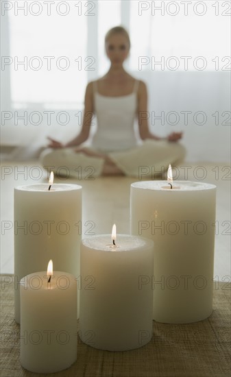 Woman meditating with candles.