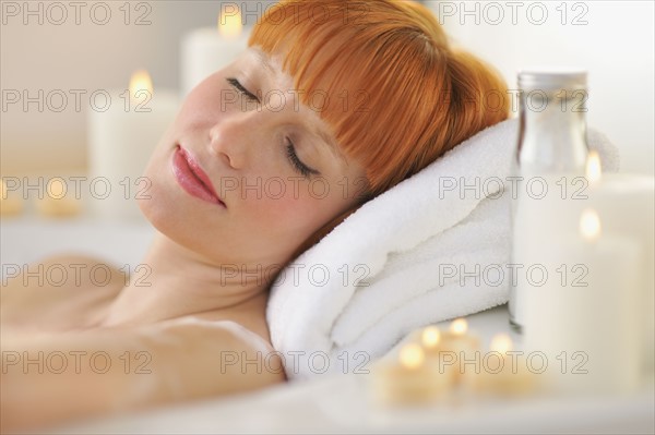 Woman relaxing in bathtub.