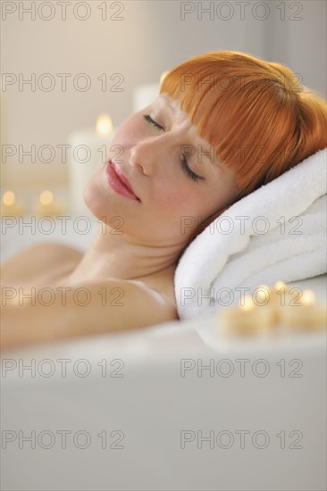 Woman relaxing in bathtub.