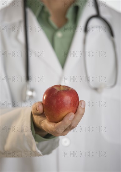 Doctor holding apple.