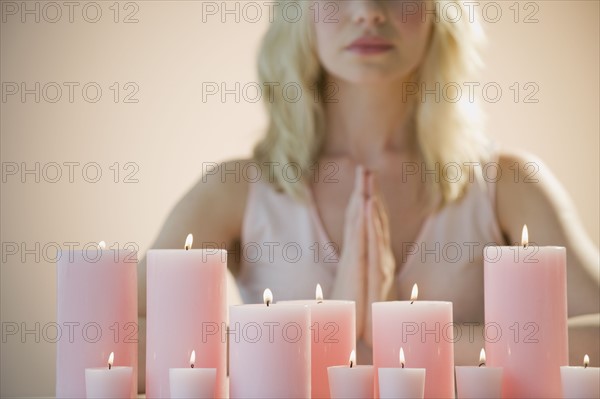 Woman meditating with candles.