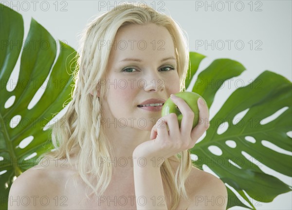 Woman eating green apple.