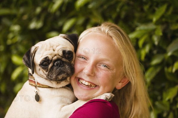 Fillette tenant un chien dans ses bras