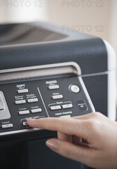 Woman using photocopier, close-up.