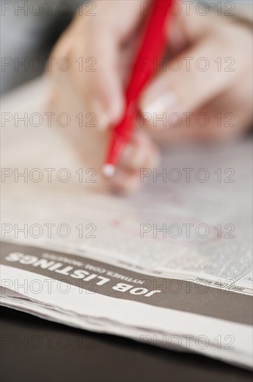 Woman circling classfields, close-up.