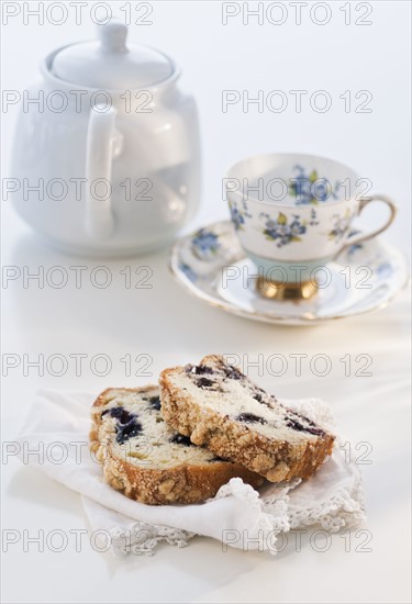 Two slices of cake, teapot and tea cup.