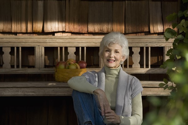 Portrait of senior woman relaxing outside home. Photographe : mark edward atkinson