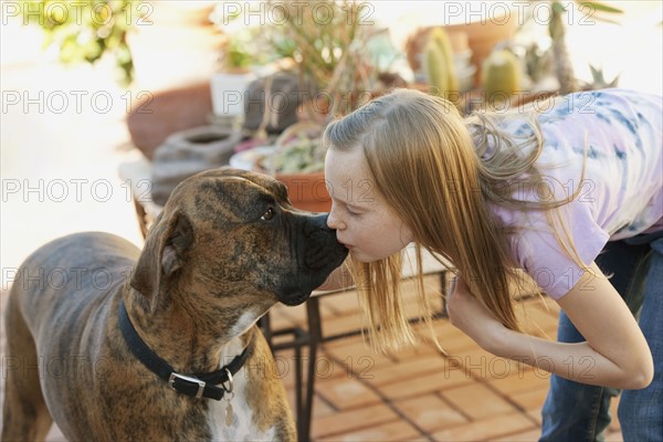 Girl (10-12) kissing boxer. Photographe : Sarah M. Golonka