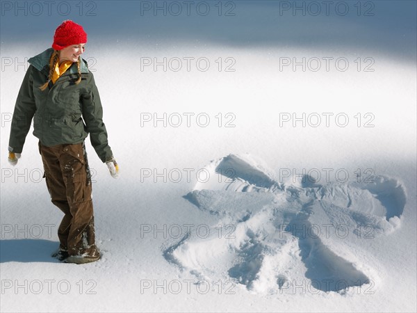 Woman looking at snow angel shape. Photographe : John Kelly