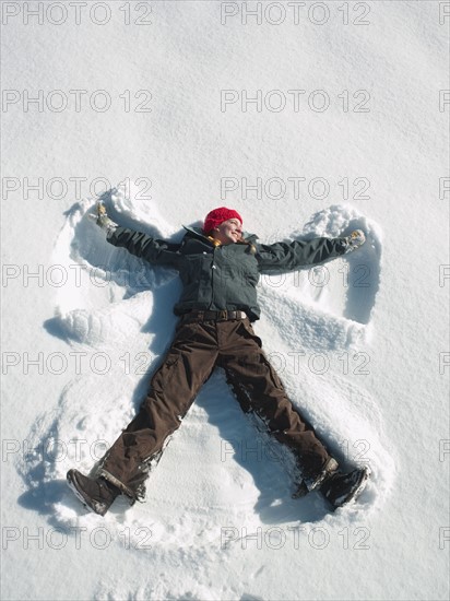 Woman making snow angel. Photographe : John Kelly