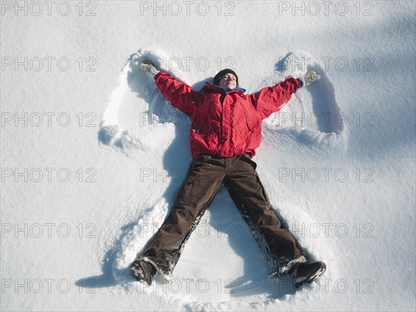 Woman making snow angel. Photographe : John Kelly