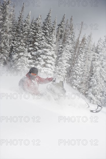 Man driving snowmobile Aspen, Colorado, USA. Photographe : Shawn O'Connor