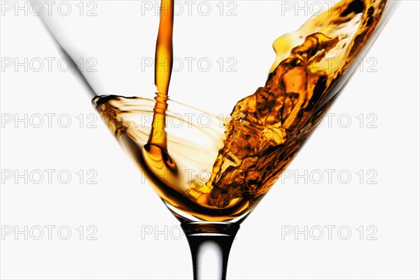 Drink being poured into wineglass, close-up. Photographe : Joe Clark