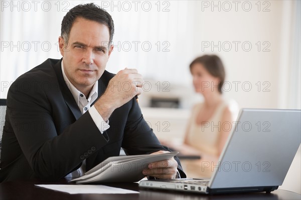 Portrait of successful mature businessman working in office.