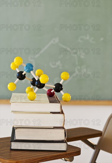 Molecule model on stack of books.
