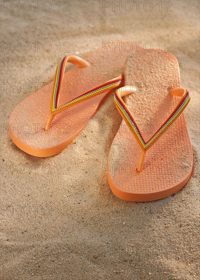 Pair of thongs on sand.