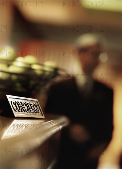 Information sign in hotel reception and man in background, Dallas, Texas, USA. Photographe : Stewart Cohen