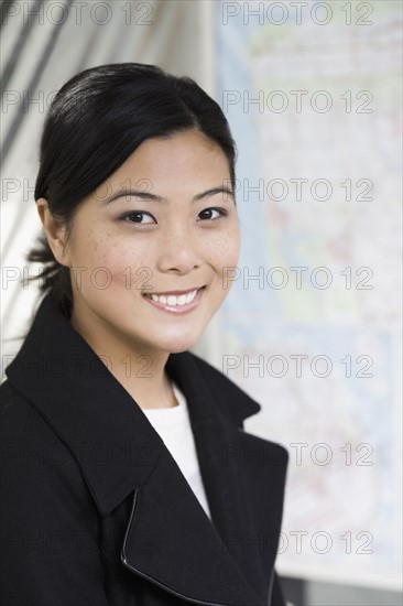 Portrait of young woman waiting at bus stop. Photographe : PT Images