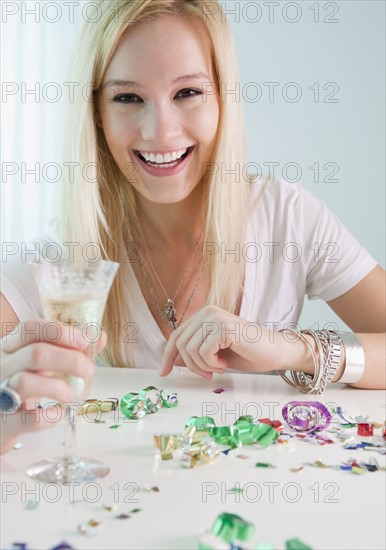 Portrait of young woman holding champagne and new year's eve. Photographe : Jamie Grill