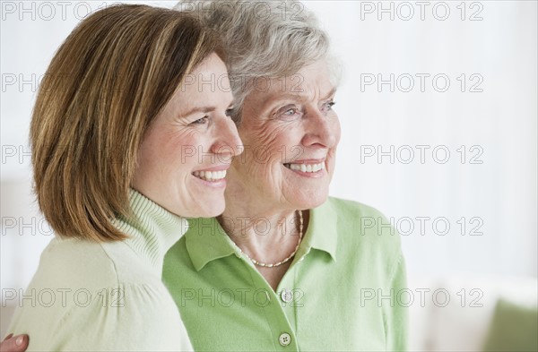 Daughter hugging mother side by side.