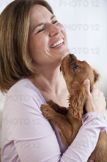 Mature woman hugging puppy.