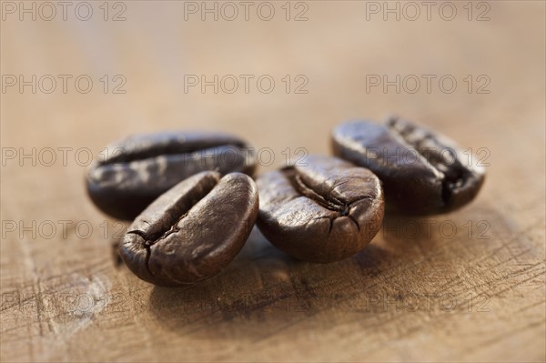 Four roast coffee beans, studio shot.