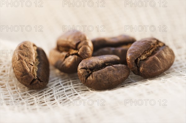 Roast coffee beans on fabric, studio shot.