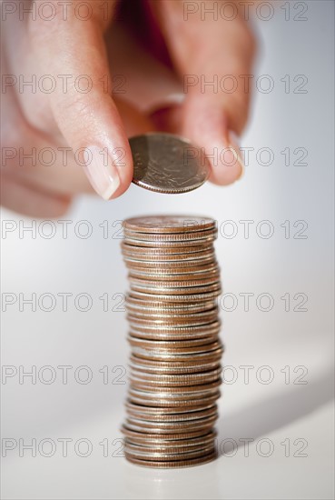 Close-up of woman's hand stacking coins.