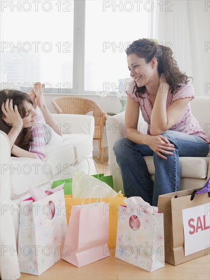 Mother and daughter (10-12 years) relaxing after shopping. Photographe : Jamie Grill