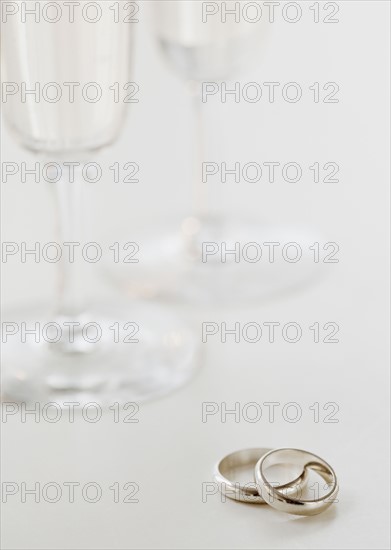 Two wedding rings by wineglasses. Photographe : Jamie Grill