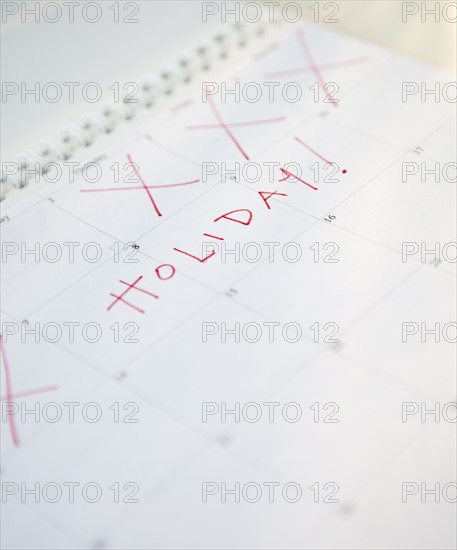 Close-up of holiday written on calendar. Photographe : Jamie Grill
