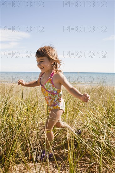 Beaver Island, Girl running in grass on beach, Beaver Island, Michigan, USA. Photographe : Shawn O'Connor