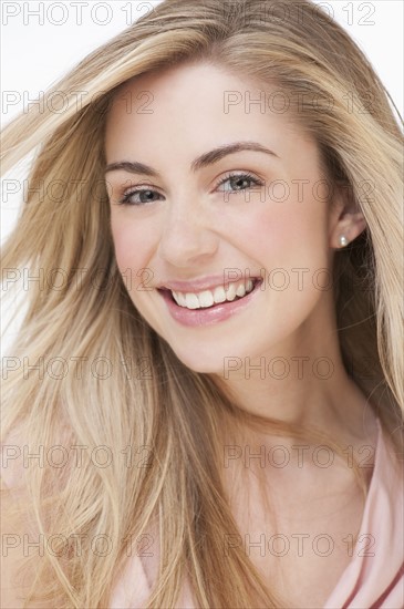 Studio portrait of young woman smiling. Photographe : Daniel Grill