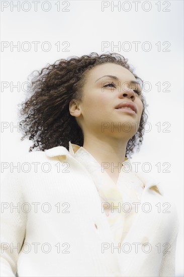 Young woman smiling, outdoors. Photographe : PT Images