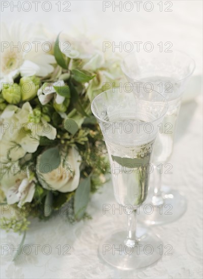 Bouquet of flowers by champagne, studio shot. Photographe : Jamie Grill